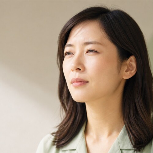 遠くを見て見えにくさを感じている日本人女性