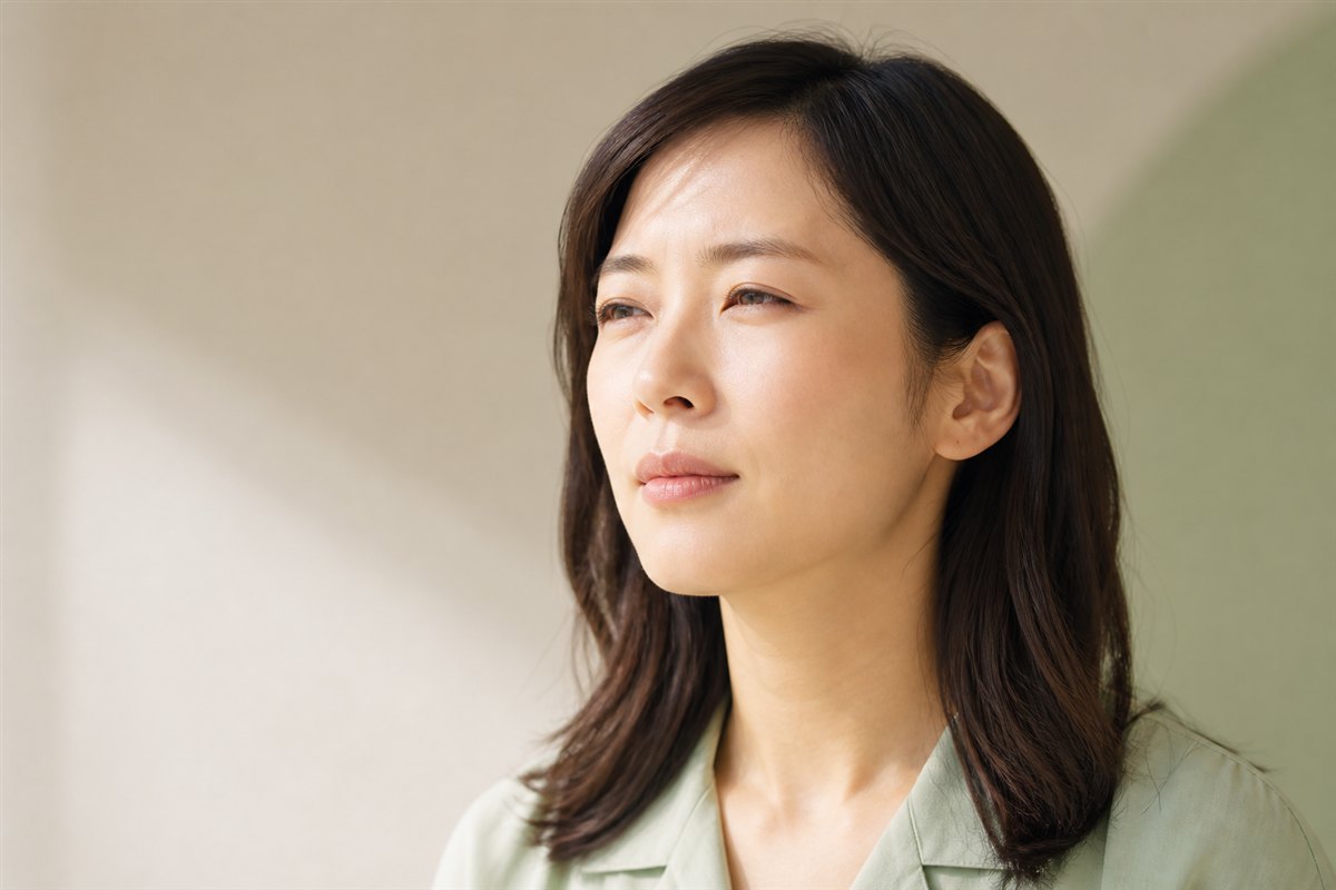 遠くを見て見えにくさを感じている日本人女性